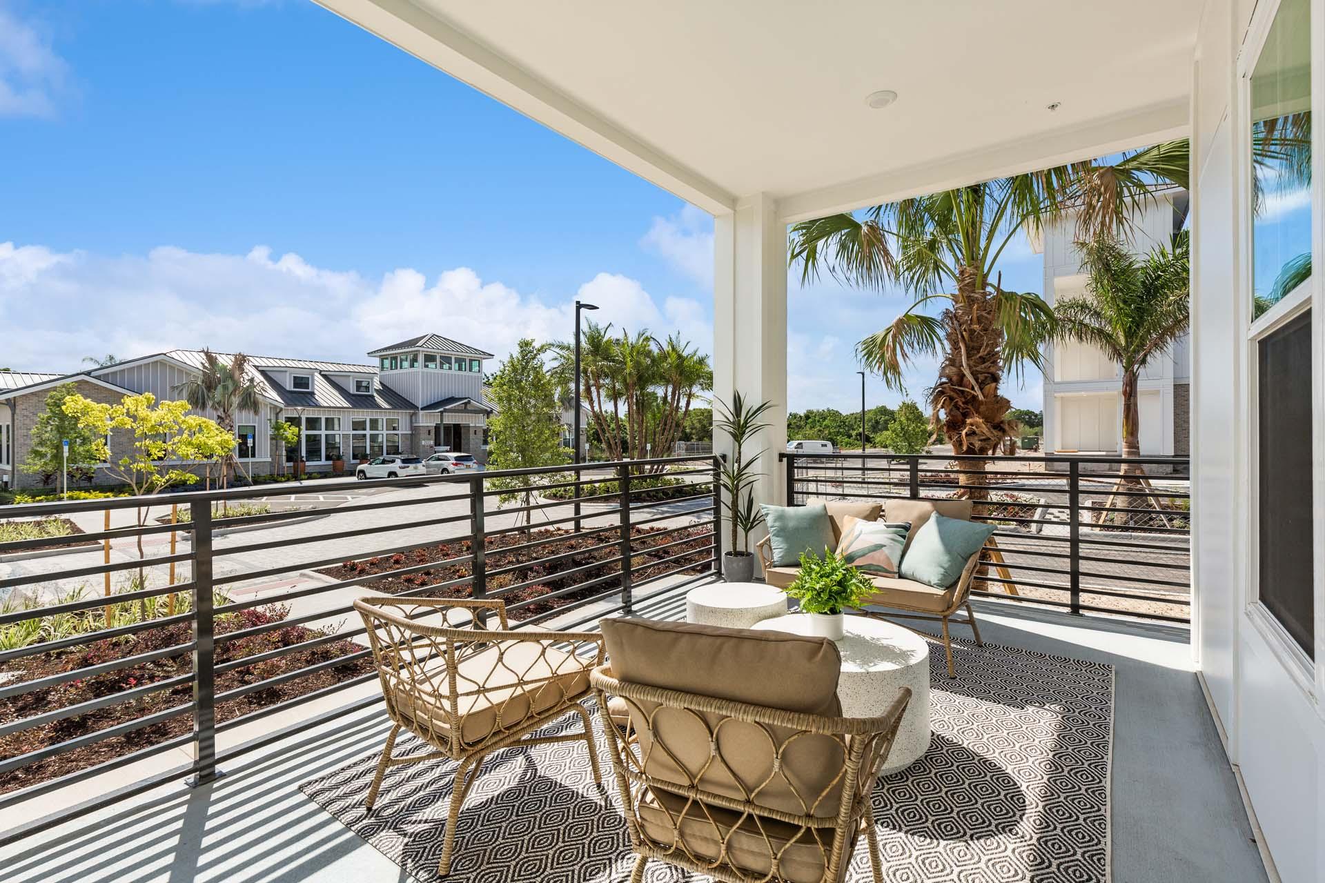 Outdoor seating area with palm trees and bright sky