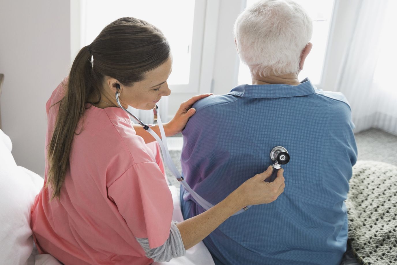 Nurse checking a patient's heart with a stethoscope