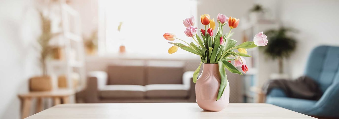 A vase of tulips on a table in a cozy room