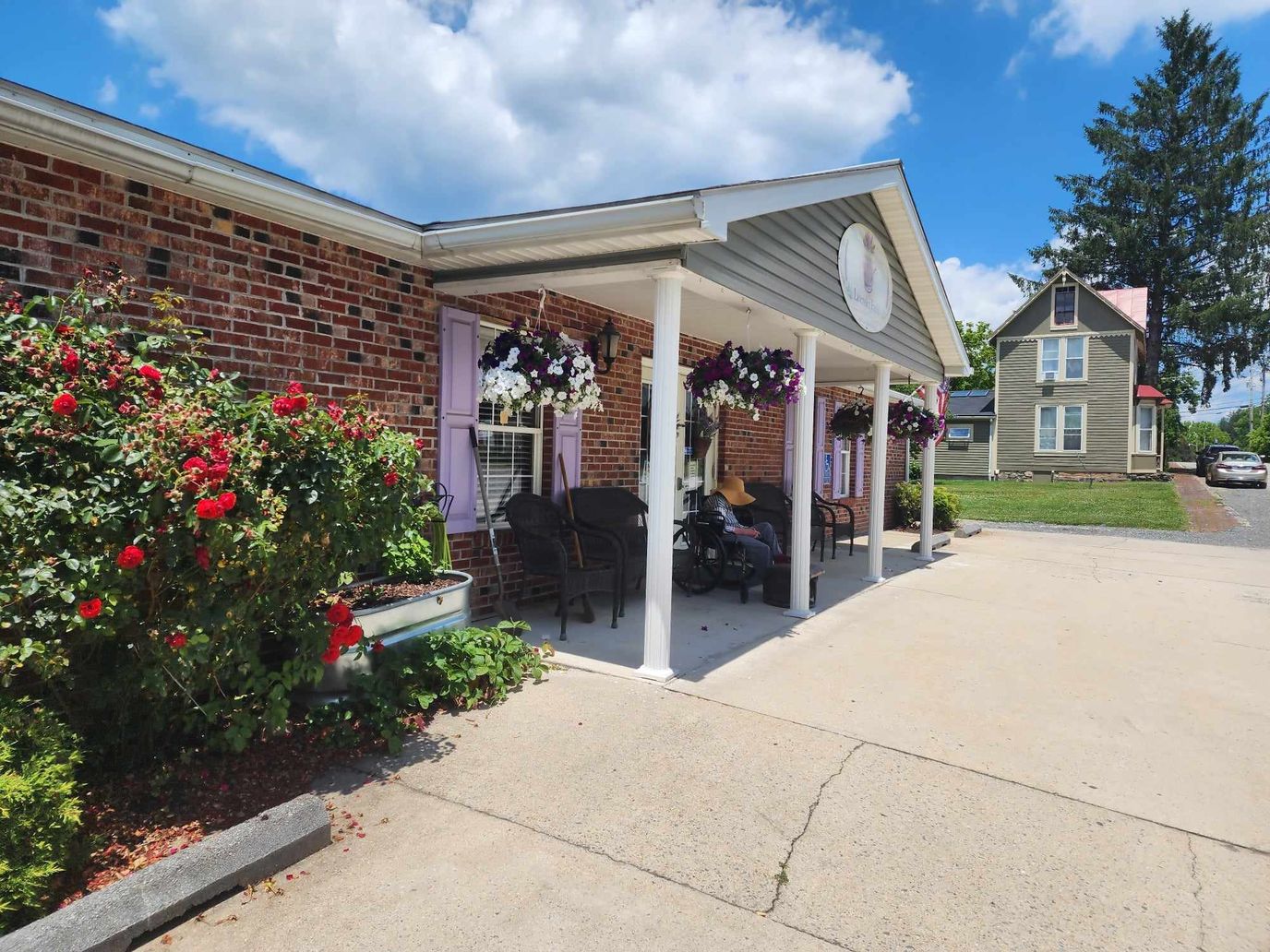 Covered porch with flowers and a resident in a wheelchair