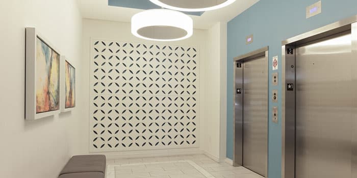 Interior hallway with elevator access and decorative wall.