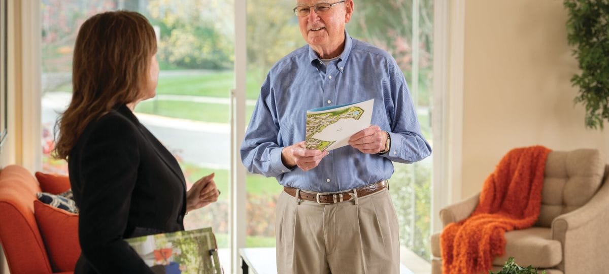 Resident interacting with staff in a bright, welcoming space.