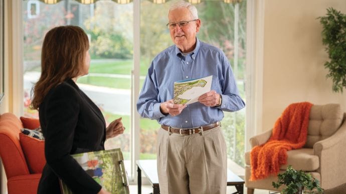 A resident conversing with a staff member indoors.