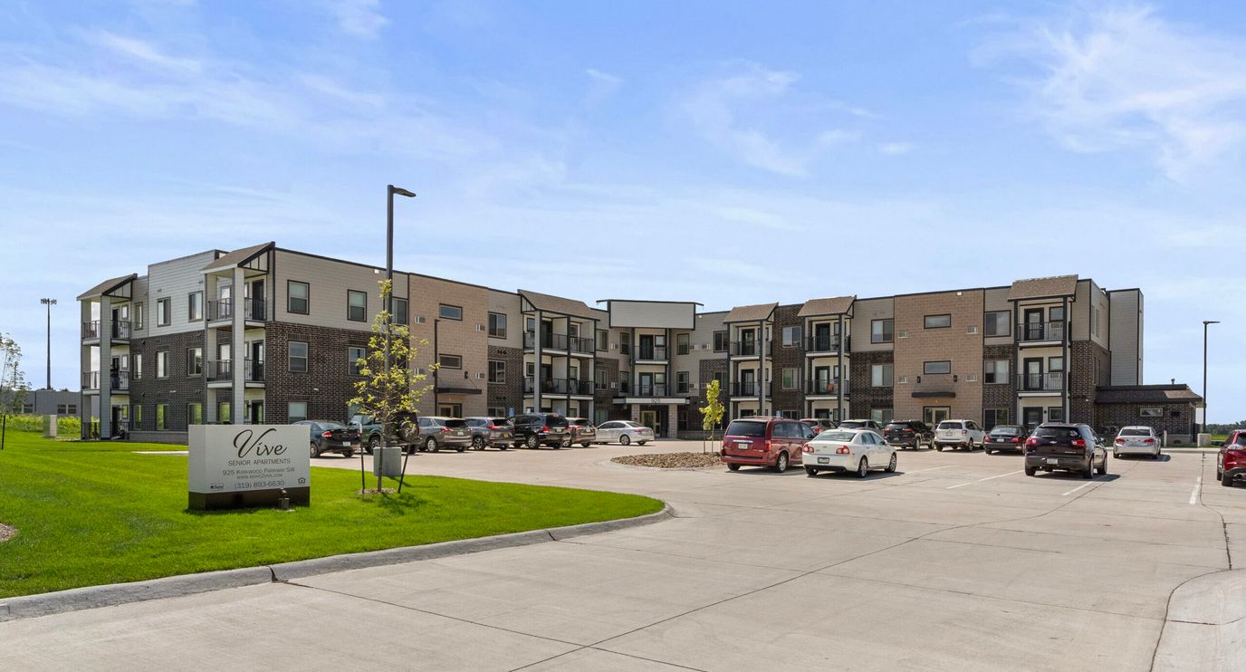 Exterior view of Vive Senior Apartments with parking lot