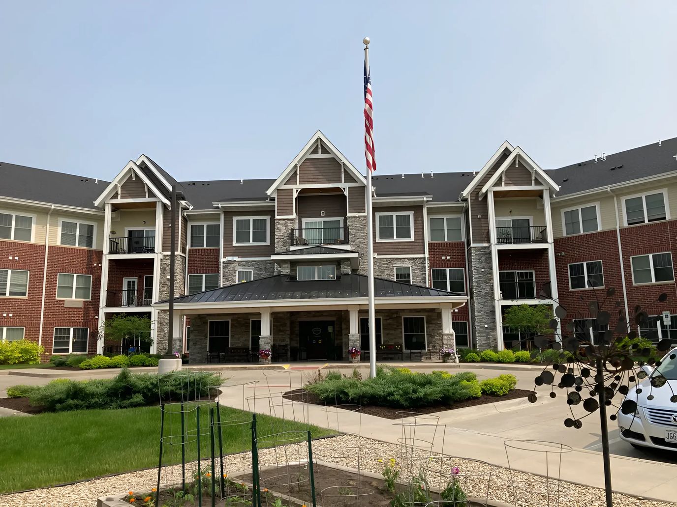 Exterior view of a senior living facility with gardens