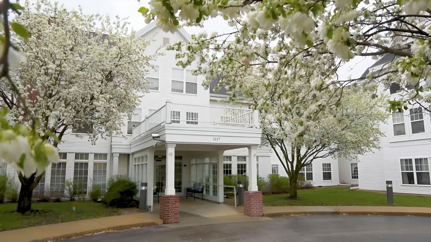 Exterior view of a senior living facility with blooming trees