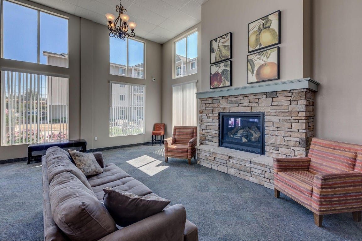 Spacious living room with a sofa, chairs, and a fireplace.