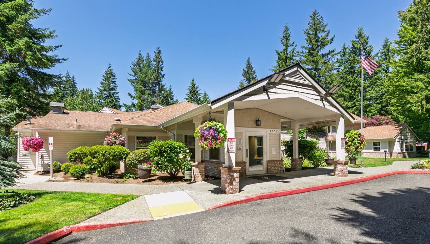 Exterior view of a senior living facility with gardens