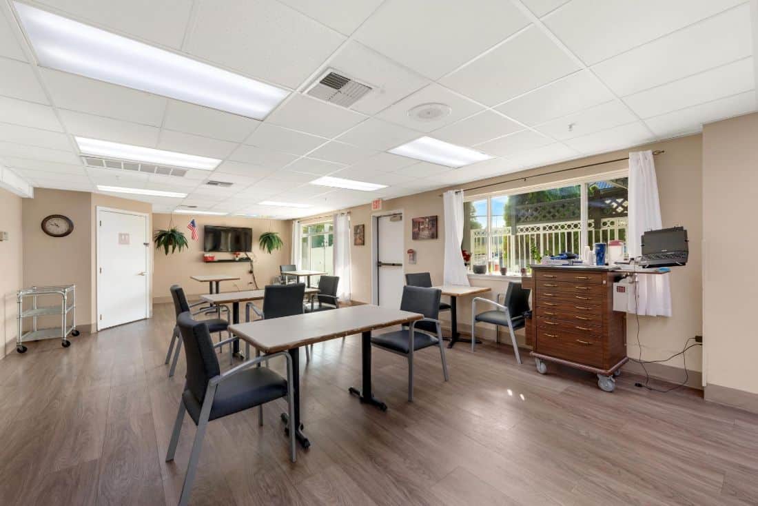 A bright room with tables and chairs in a facility