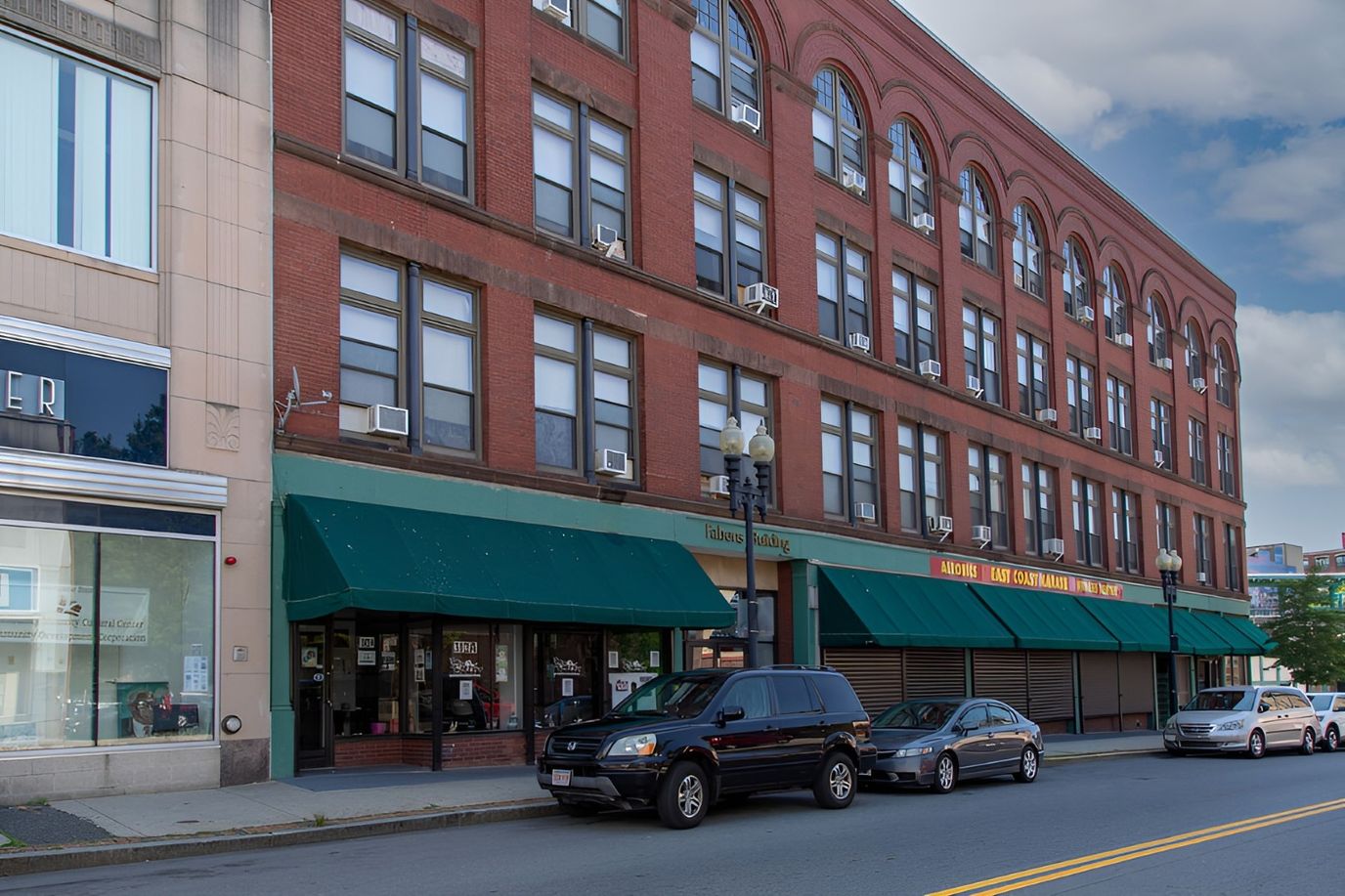 Exterior view of Fabens Building with parked vehicles