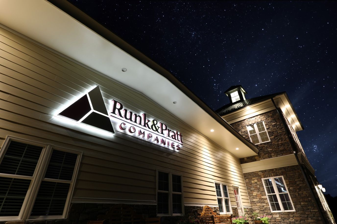 Facility logo illuminated on exterior wall at night