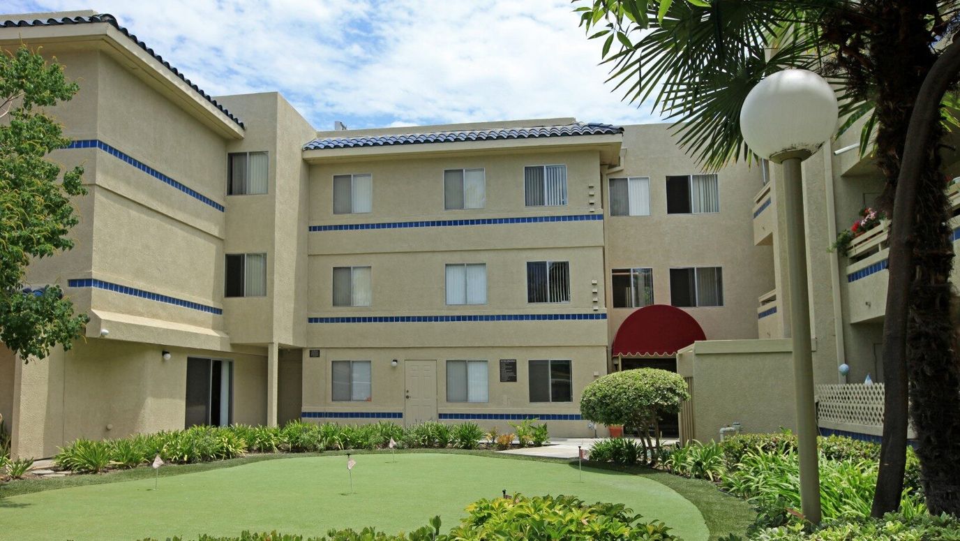 Exterior view of a senior living facility with gardens