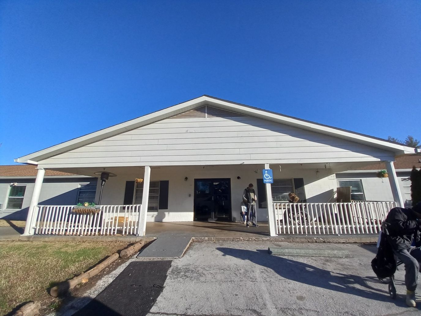 Exterior view of the nursing home with residents entering