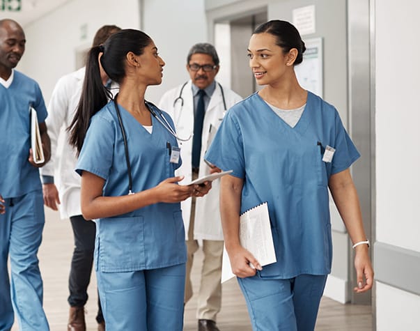 Healthcare staff engaging in conversation in a hallway