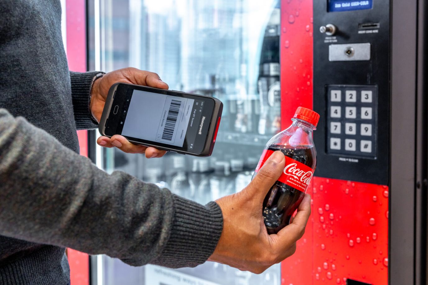 Cona, LLC, assisted living in Bowie, MD — Person using a smartphone to purchase a soda