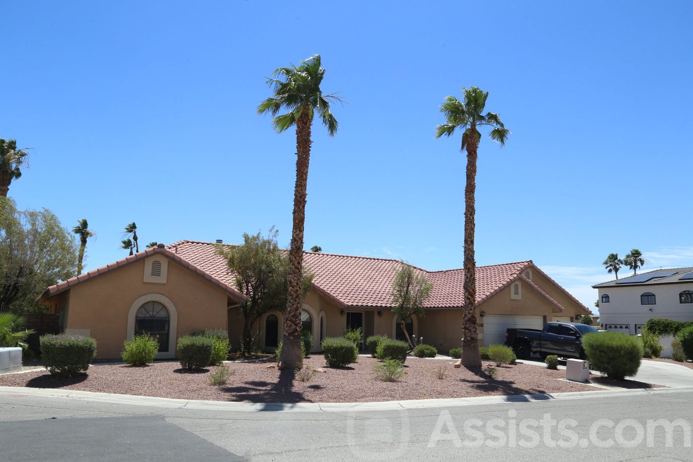 Exterior view of a senior care home with palm trees