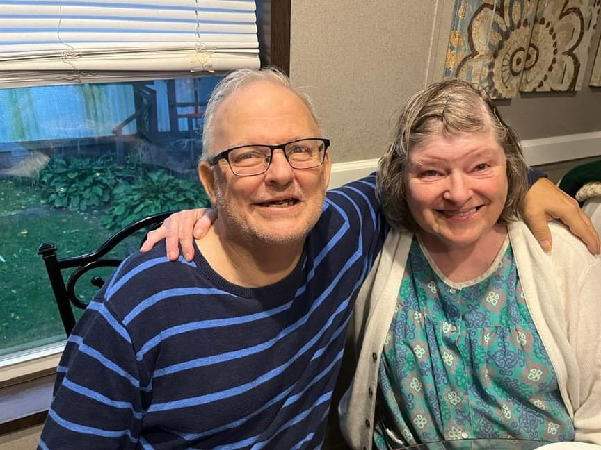 Two residents smiling together at a table