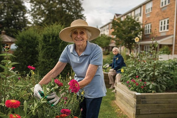 Senior woman gardening in a beautiful outdoor space.
