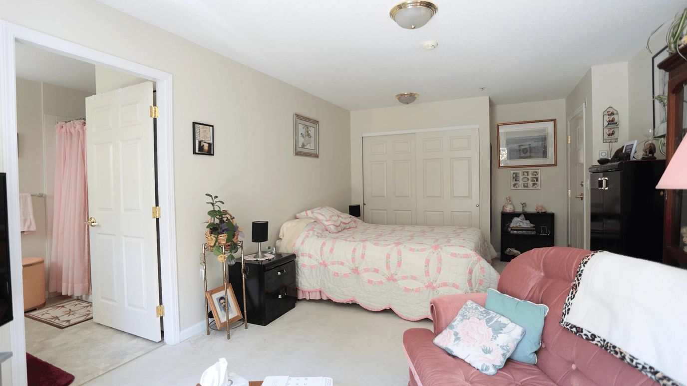 Cozy private resident room with bed and seating.