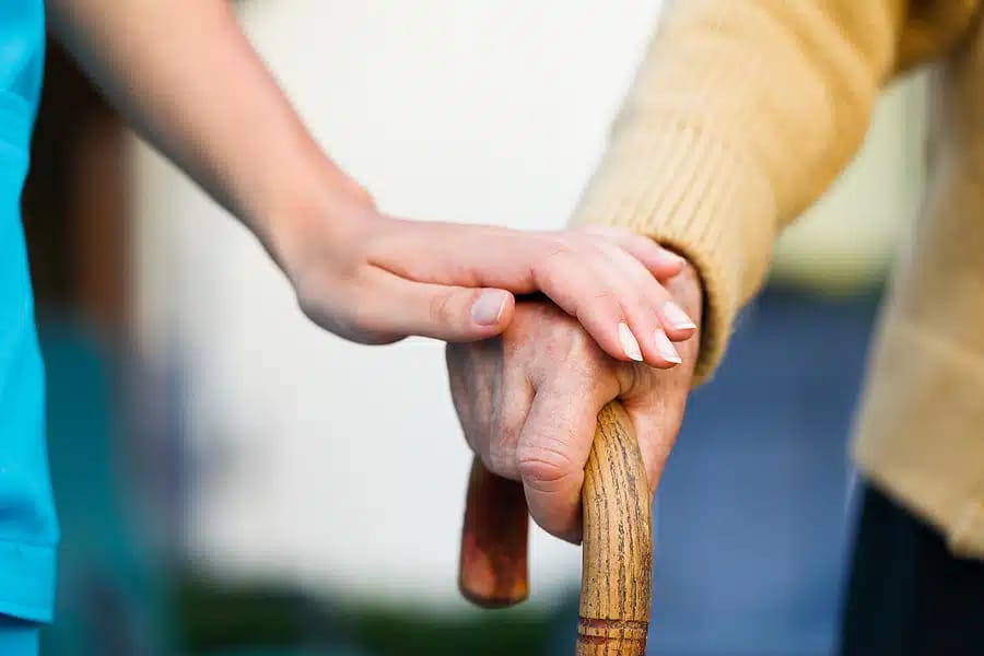 Close-up of a caregiver's and resident's hands