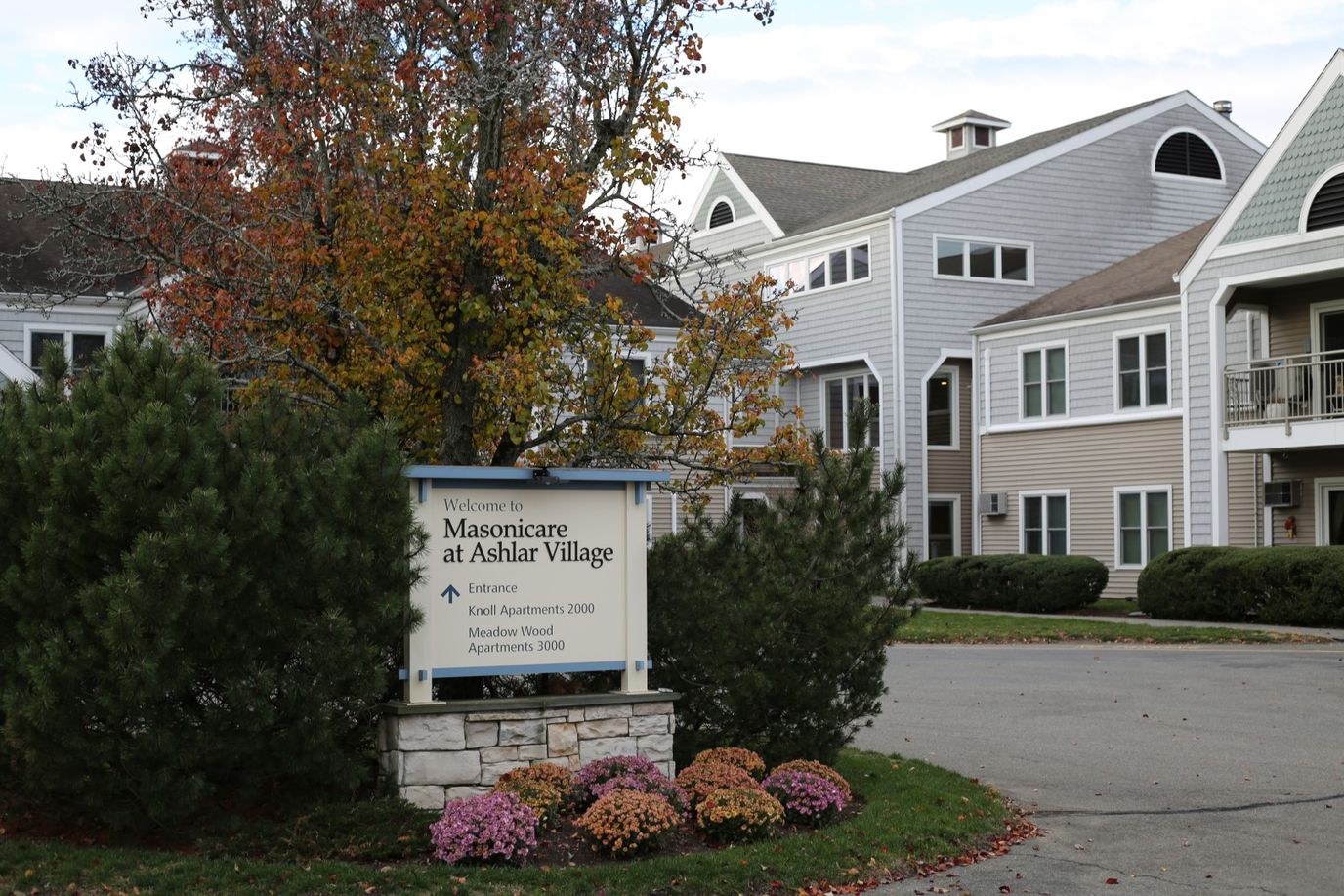 Sign for Masonicare at Ashlar Village with autumn foliage
