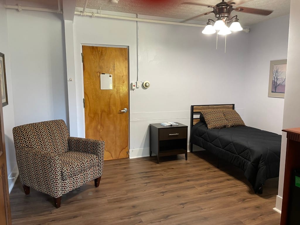 Simple room interior with a bed and armchair