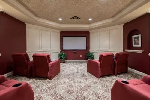 Cozy private movie room with red chairs