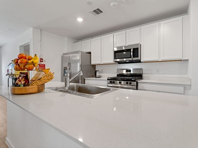 Modern kitchen with fruit display and stainless appliances