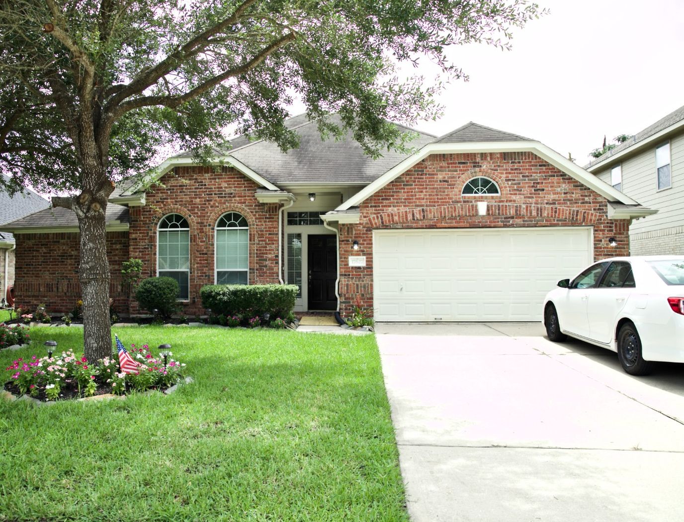 Exterior view of a brick house with a green lawn