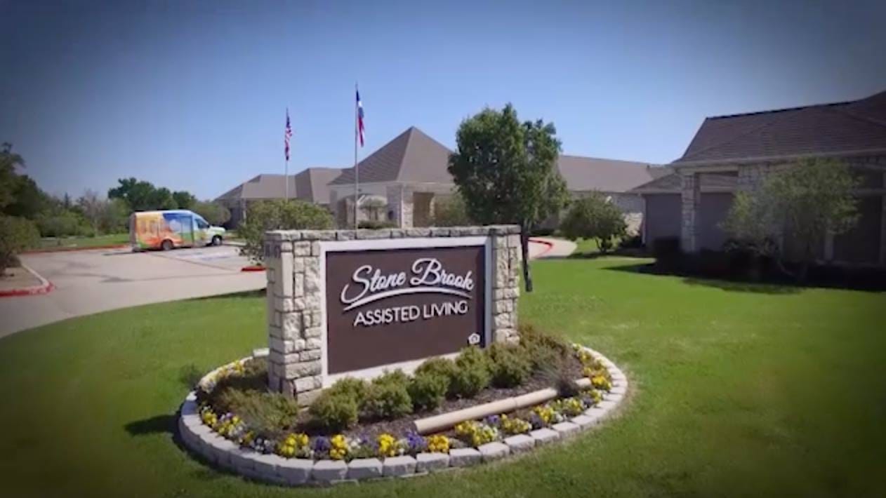 Exterior view of Stone Brook Assisted Living facility with signage