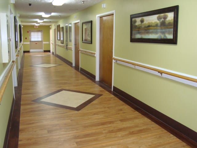 Brightly lit corridor with artwork and wooden flooring