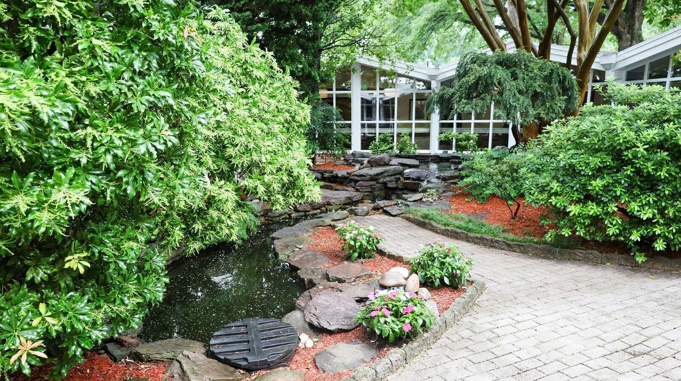 Lush garden area with a pond and pathway