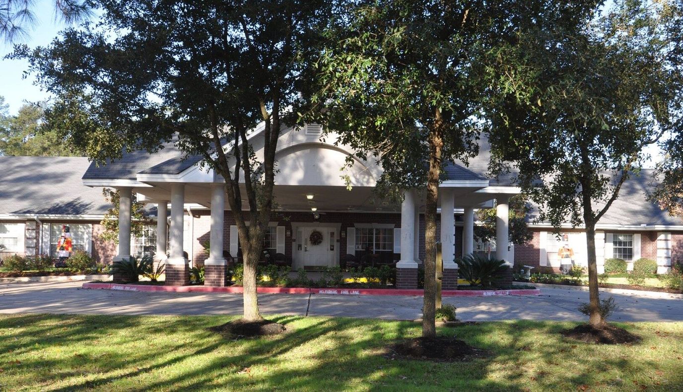Exterior view of Park Manor of Conroe surrounded by trees