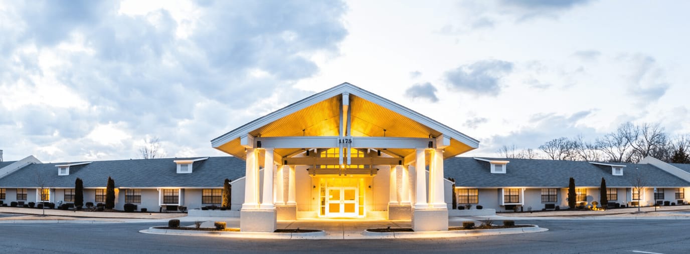 Front entrance of Heritage Living Center bathed in warm light