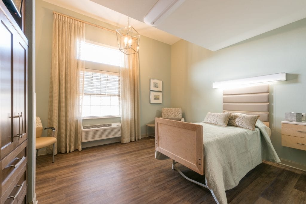 Bright private resident room with a bed and seating area