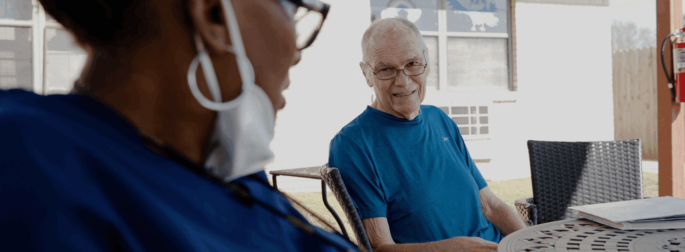 Resident and staff member conversing outdoors