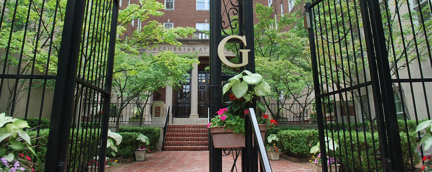 Entrance gates with flowers leading to a building