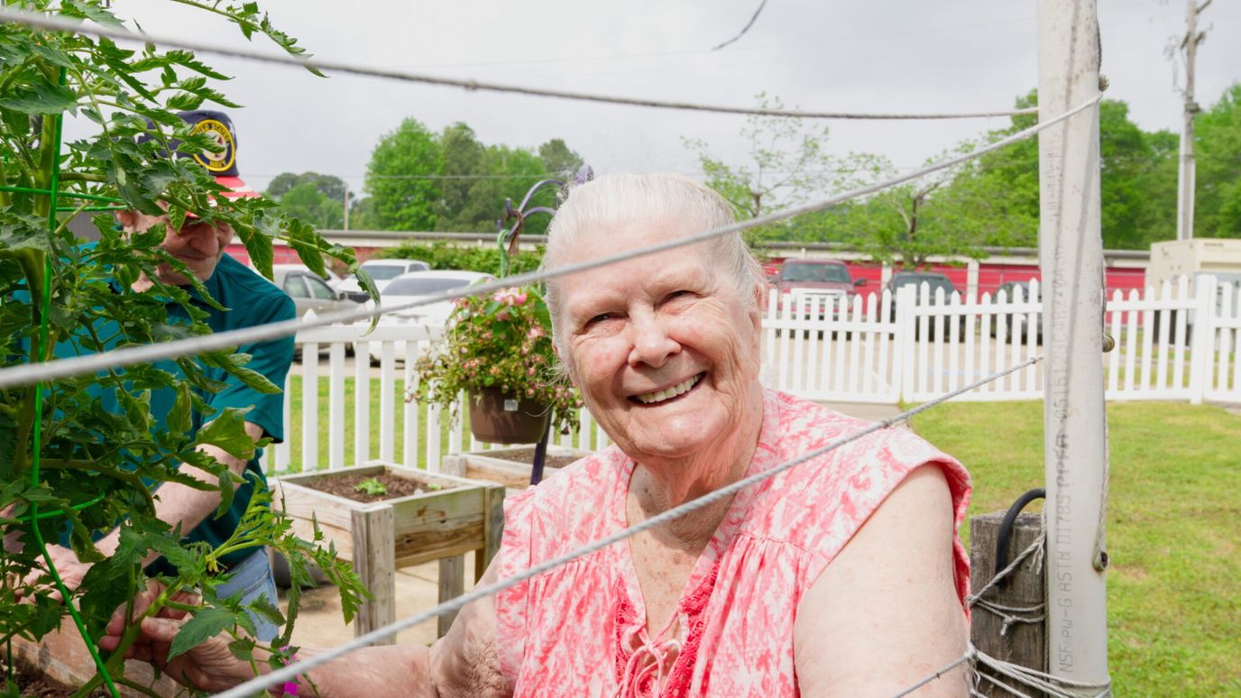 Heritage Living Center, Nursing Home in Conway, AR — Resident gardening in a sunny outdoor space