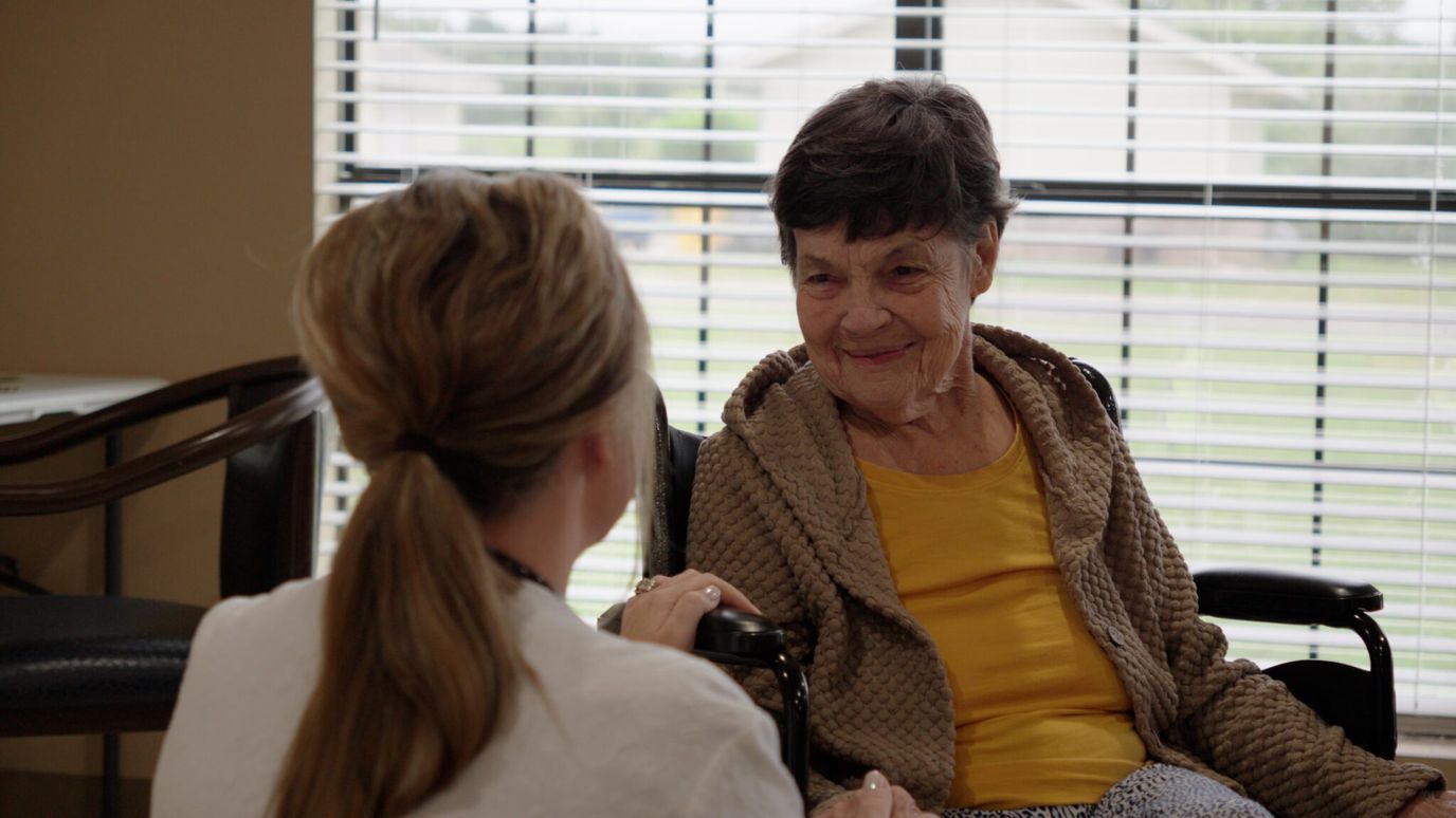 Resident interacting with staff in a cozy lounge