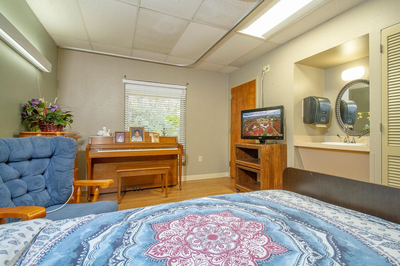 Cozy bedroom in a senior living facility with piano