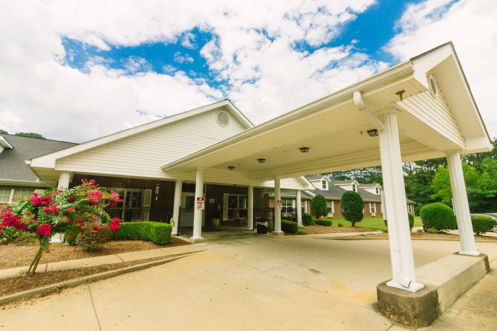 Front entrance of a senior living facility with flowers
