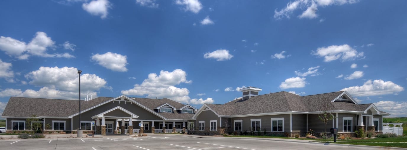 Exterior view of a senior living facility under a blue sky