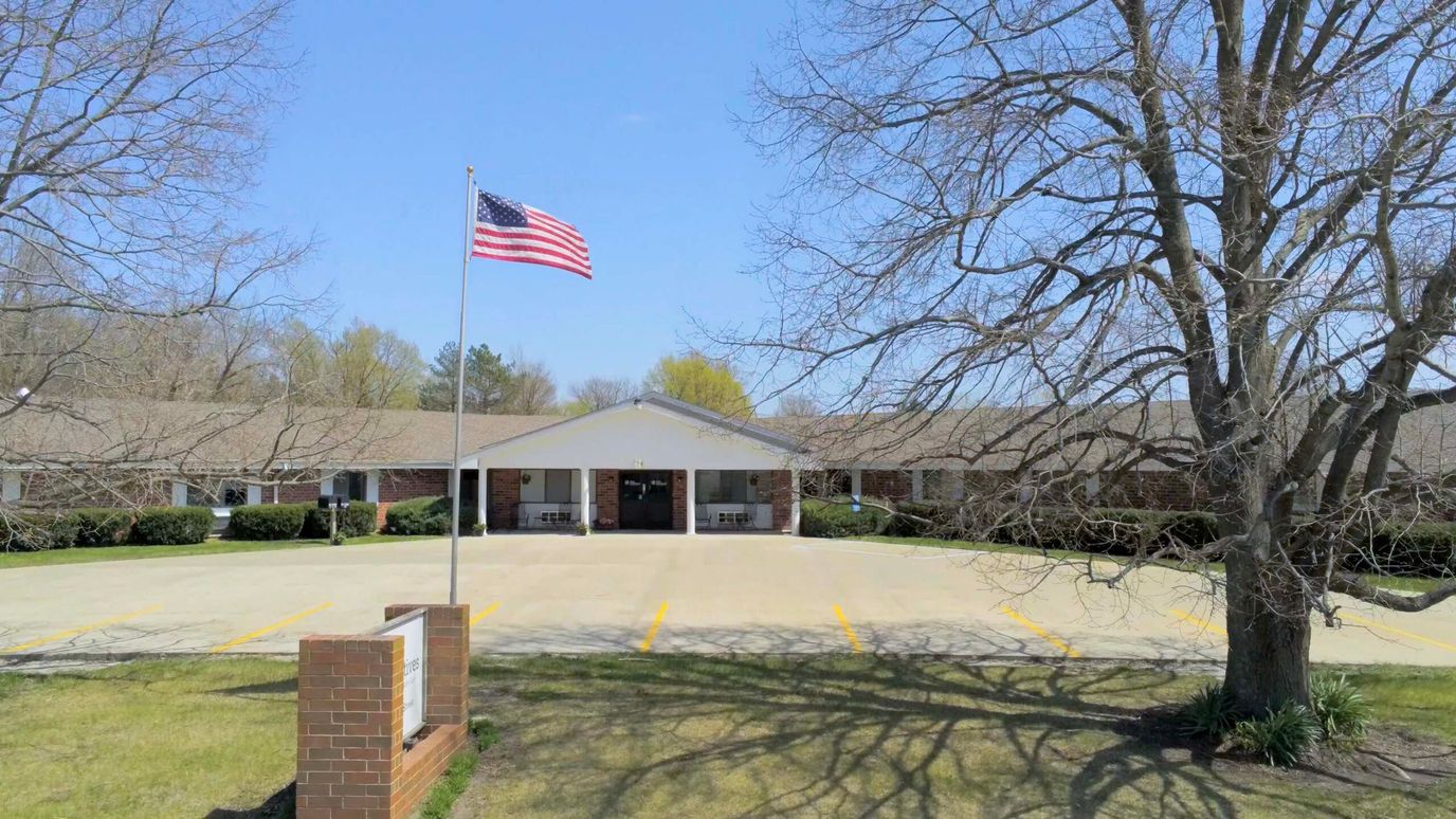 Exterior view of a senior living facility with American flag
