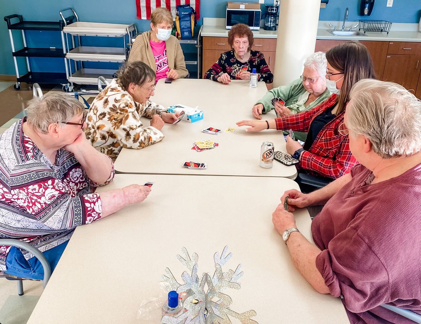 Residents playing cards in a bright activity room