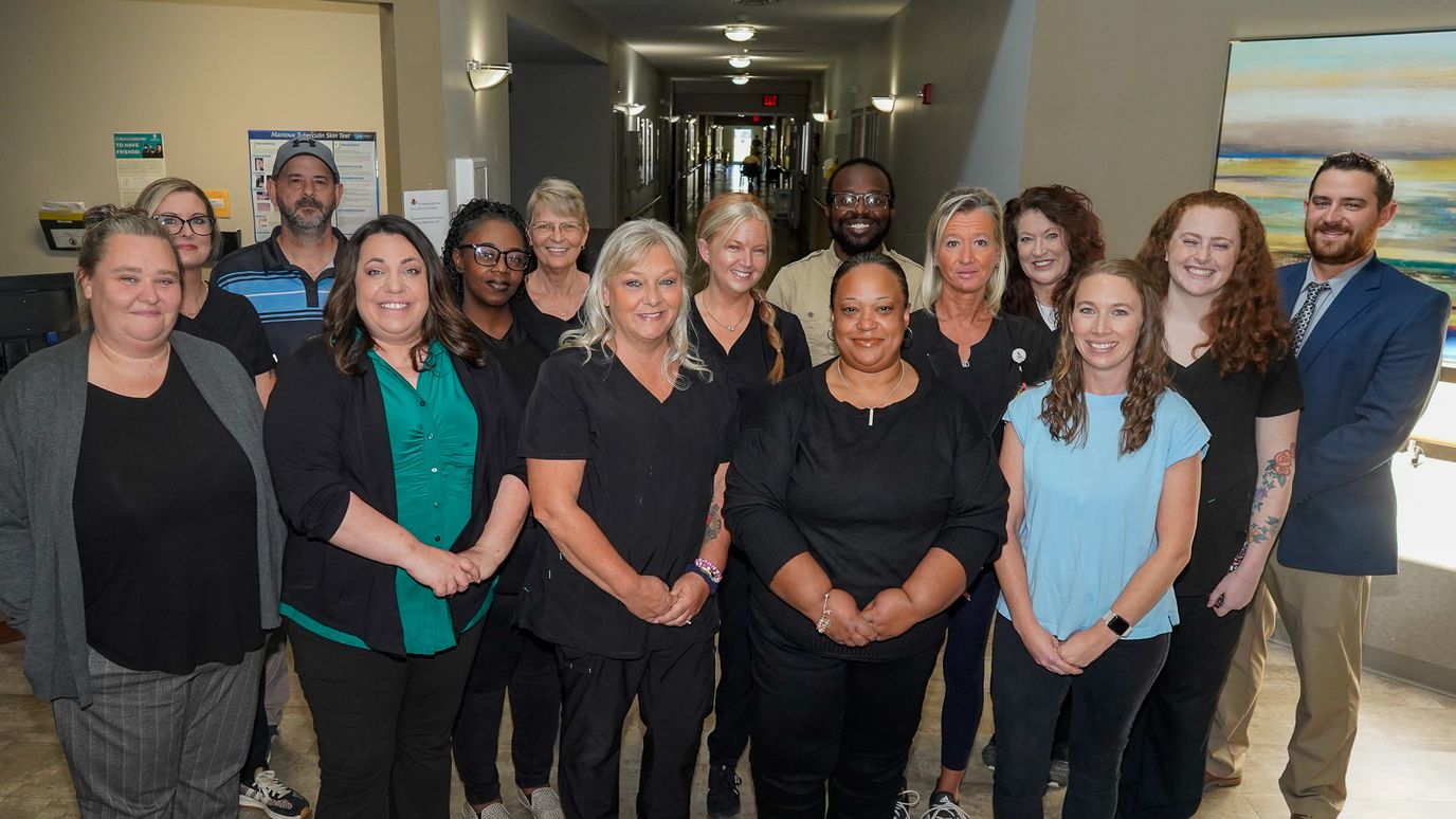 Staff members posing in a well-lit hallway