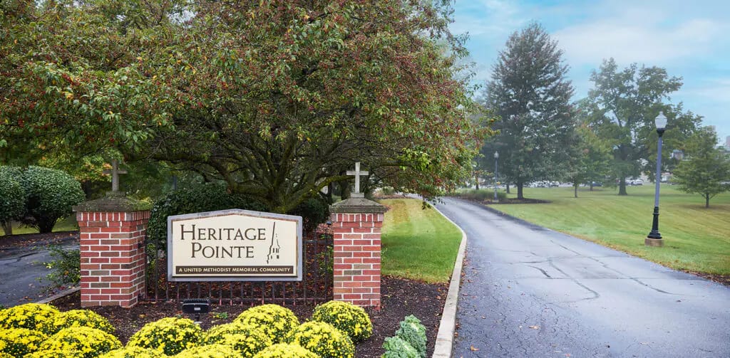 Entrance sign of a senior living facility surrounded by greenery