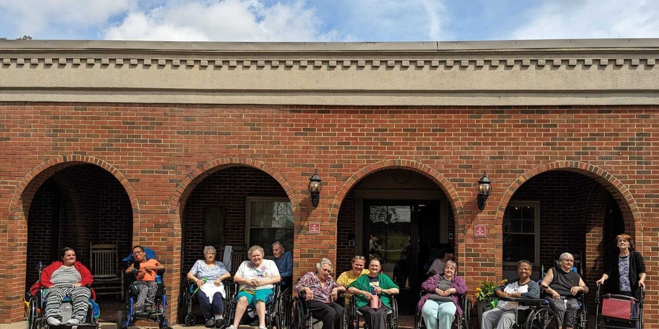 Group of residents outside the facility in wheelchairs