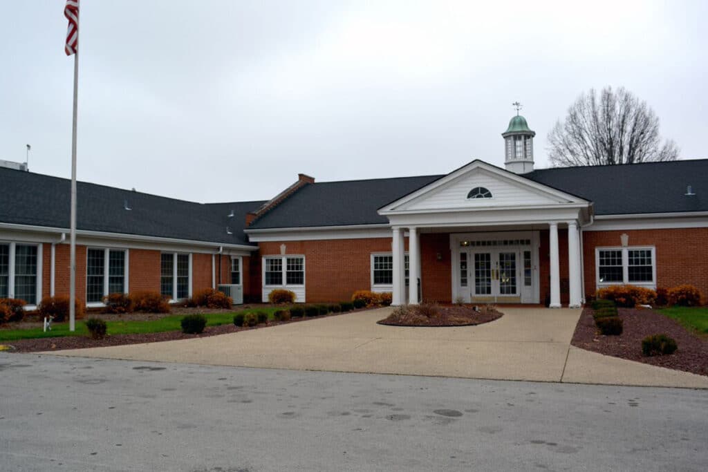 Exterior view of a senior living facility with flag