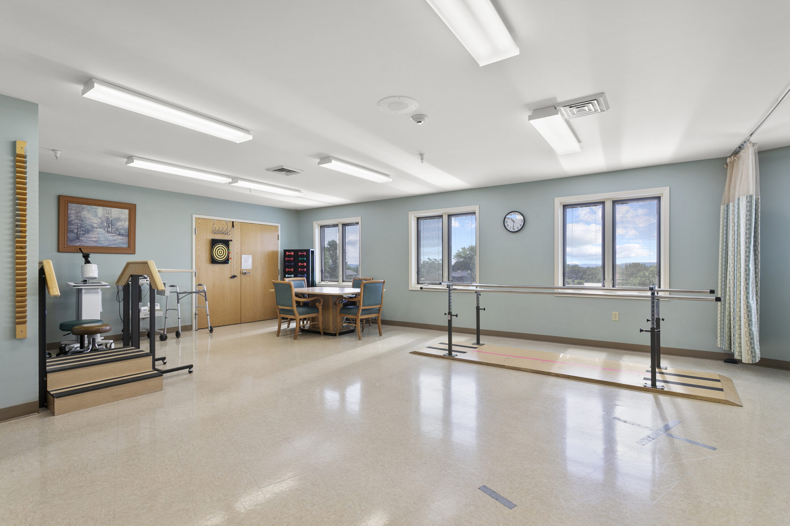 Rehabilitation therapy room with equipment and natural light