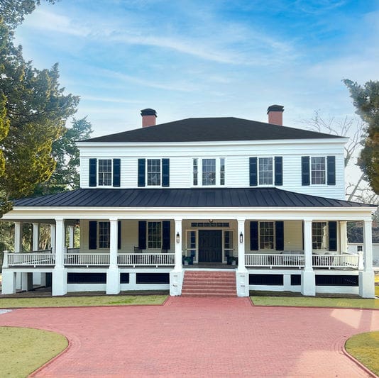 Exterior view of a senior living facility with wraparound porch